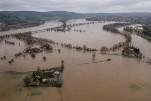 Vue aérienne d'une rivière française en crue saisonnière inondant des prairies et routes de campagne au printemps