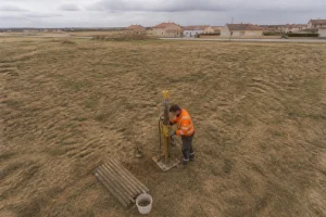 Géotechnicien réalisant un sondage de sol G1 sur un terrain constructible avec équipement de carottage