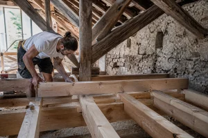 Pose d'un solivage en bois pour plafond dans des combles en rénovation